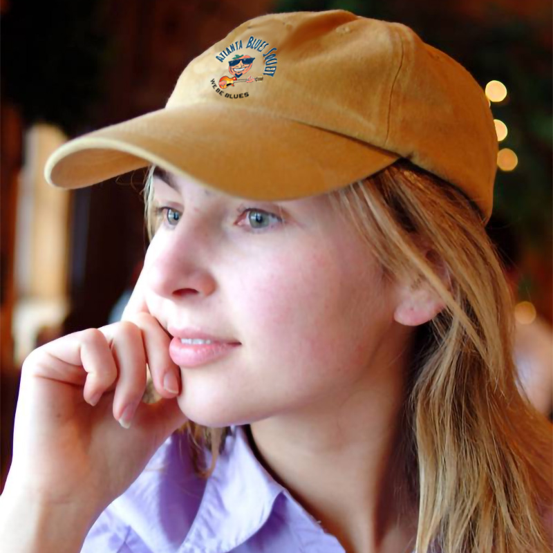 A person wearing a baseball cap looks thoughtfully to the side.